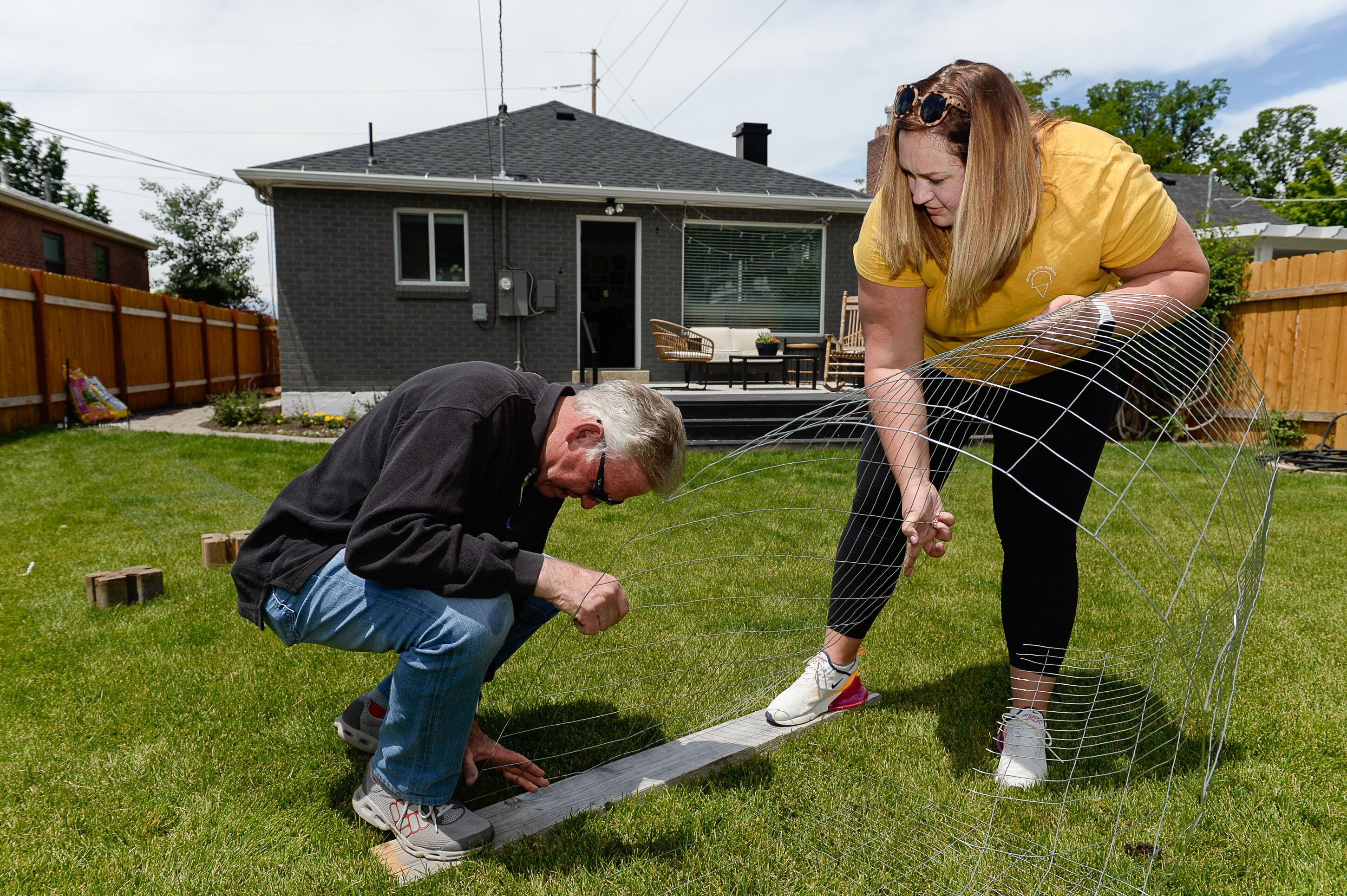 (Francisco Kjolseth | The Salt Lake Tribune) Courtney Hatch gets help from her dad Floyd installing a wire fence at her house in Sugarhouse to help keep her dogs out of her garden on Wed. June 12, 2019. Intermountain Healthcare is beginning a global collaboration and study to discover new links between genetics and human disease that will involve the collection of half-a-million DNA samples. This initiative focuses on people with the PKP2 gene, a mutation that can lead to heart failure. Both Courtney and her father have the genetic condition, and are participating in the study.