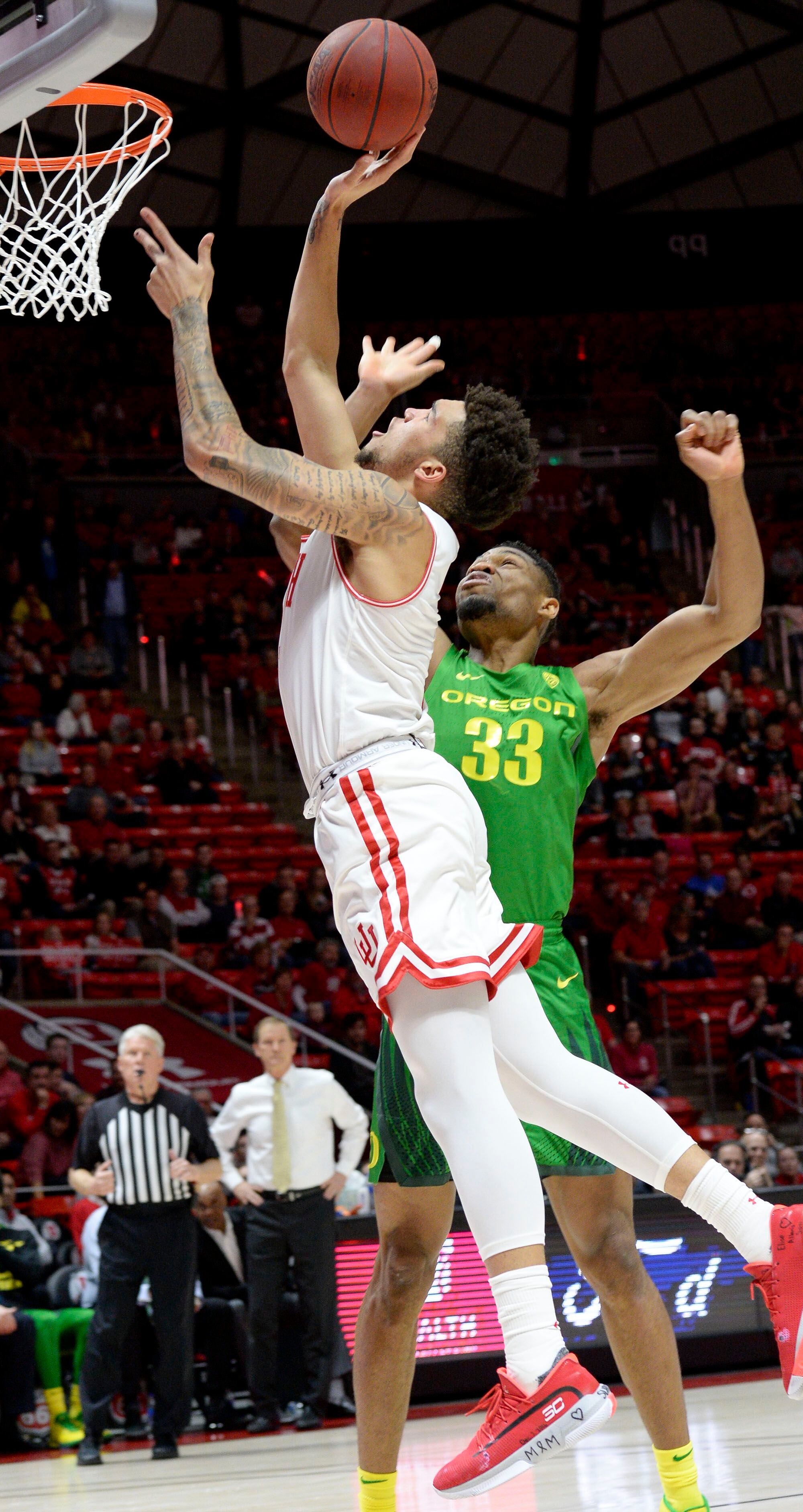 (Leah Hogsten | The Salt Lake Tribune) Utah Utes forward Timmy Allen (1) drives to the net around Oregon Ducks forward Francis Okoro (33) as the University of Utah basketball team hosts No. 4 Oregon, Jan. 4, 2020, at the Huntsman Center.