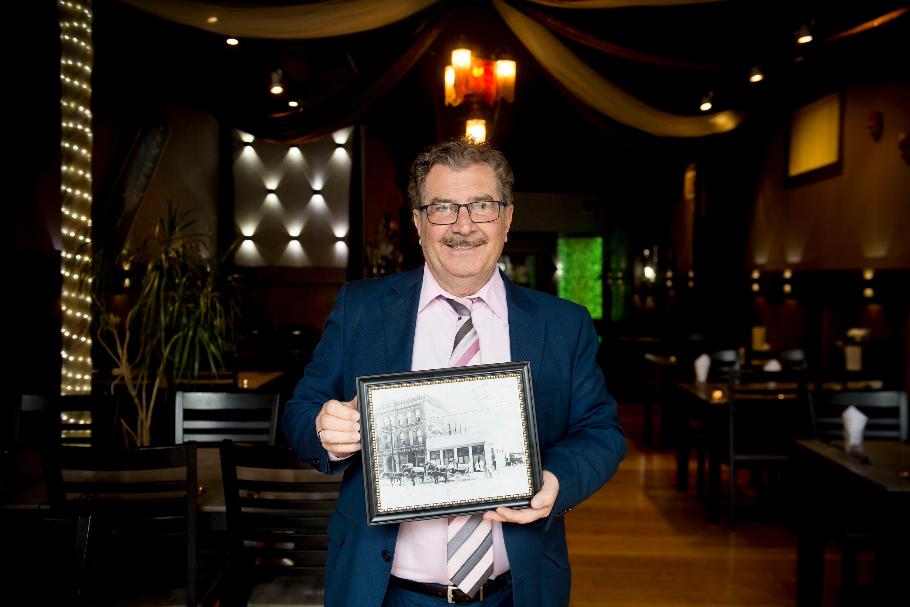 (Jeremy Harmon | The Salt Lake Tribune) Raffi Daghlian holds a picture of his restaurant, Cedars of Lebanon, as it looked in 1908. The restaurant is closing after 38 years. He is seen here on May 24, 2019.