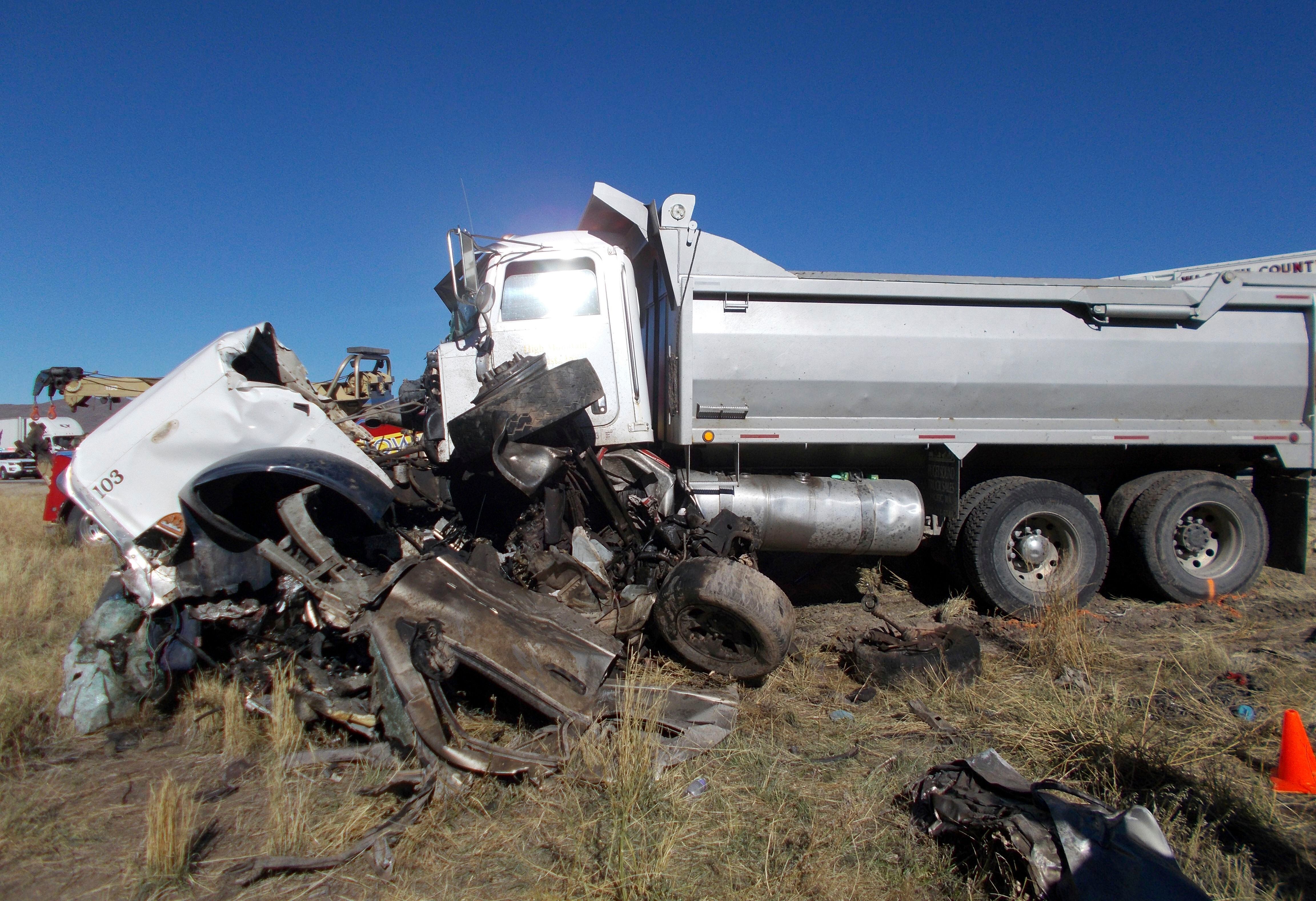 This Friday, Oct. 19, 2018 photo provided by the Utah Highway Patrol shows the scene of a head-on collision of a dump truck and a pickup on a state highway near Heber, Utah. State troopers say the dump truck crossed a highway median and collided with the pickup truck traveling in the opposite direction, killing all six men in the pickup in an accident authorities suspect may was caused by alcohol and prescription drugs. (Utah Highway Patrol via AP)