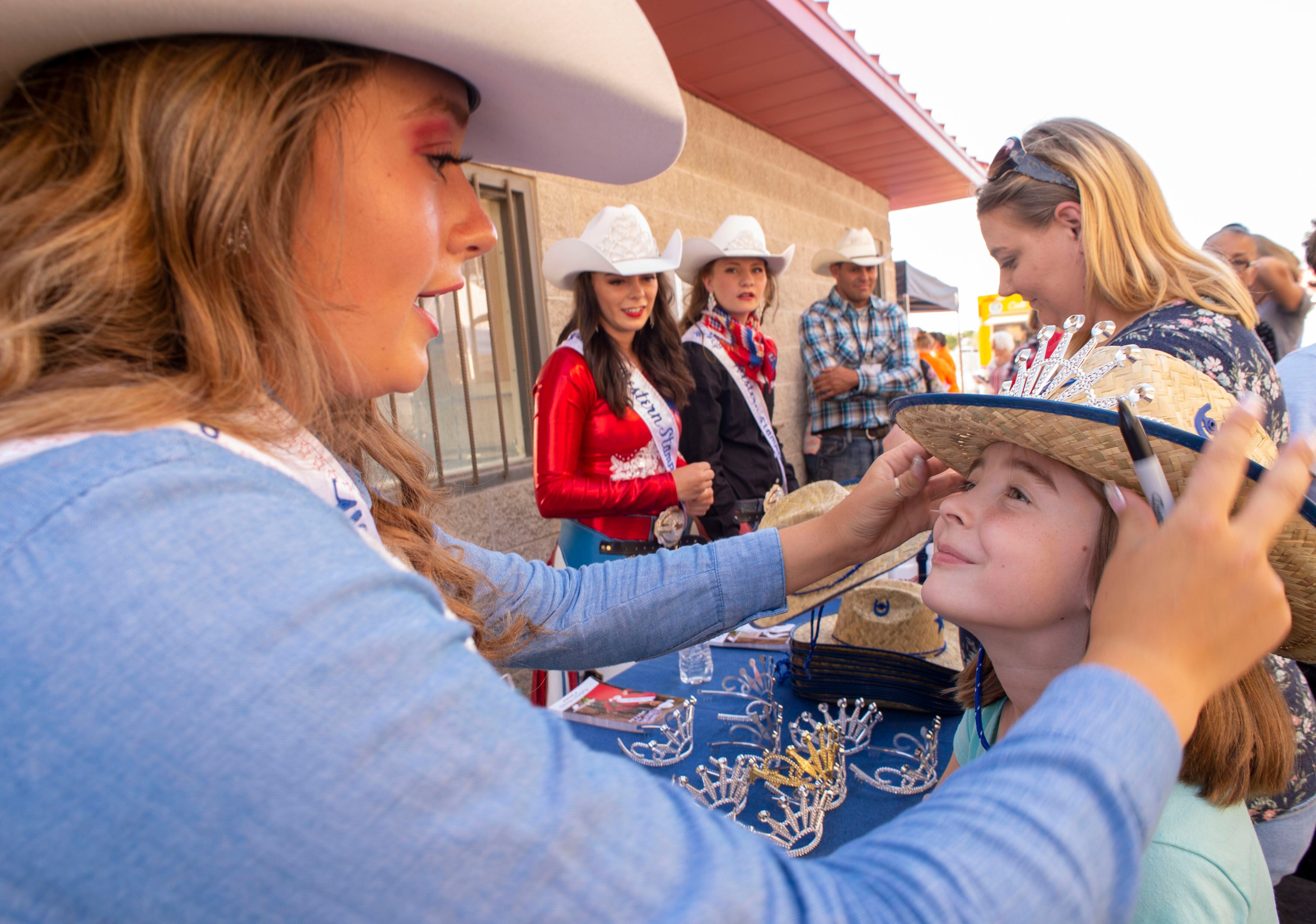 (Rick Egan | The Salt Lake Tribune) Western Stampede Second attendant Madelyn Mundy, puts a crown and a free cowboy hat on Emma Ball, 8 from Syracuse, at the West Jordan Western Stampede Rodeo, Saturday, July 6, 2019.