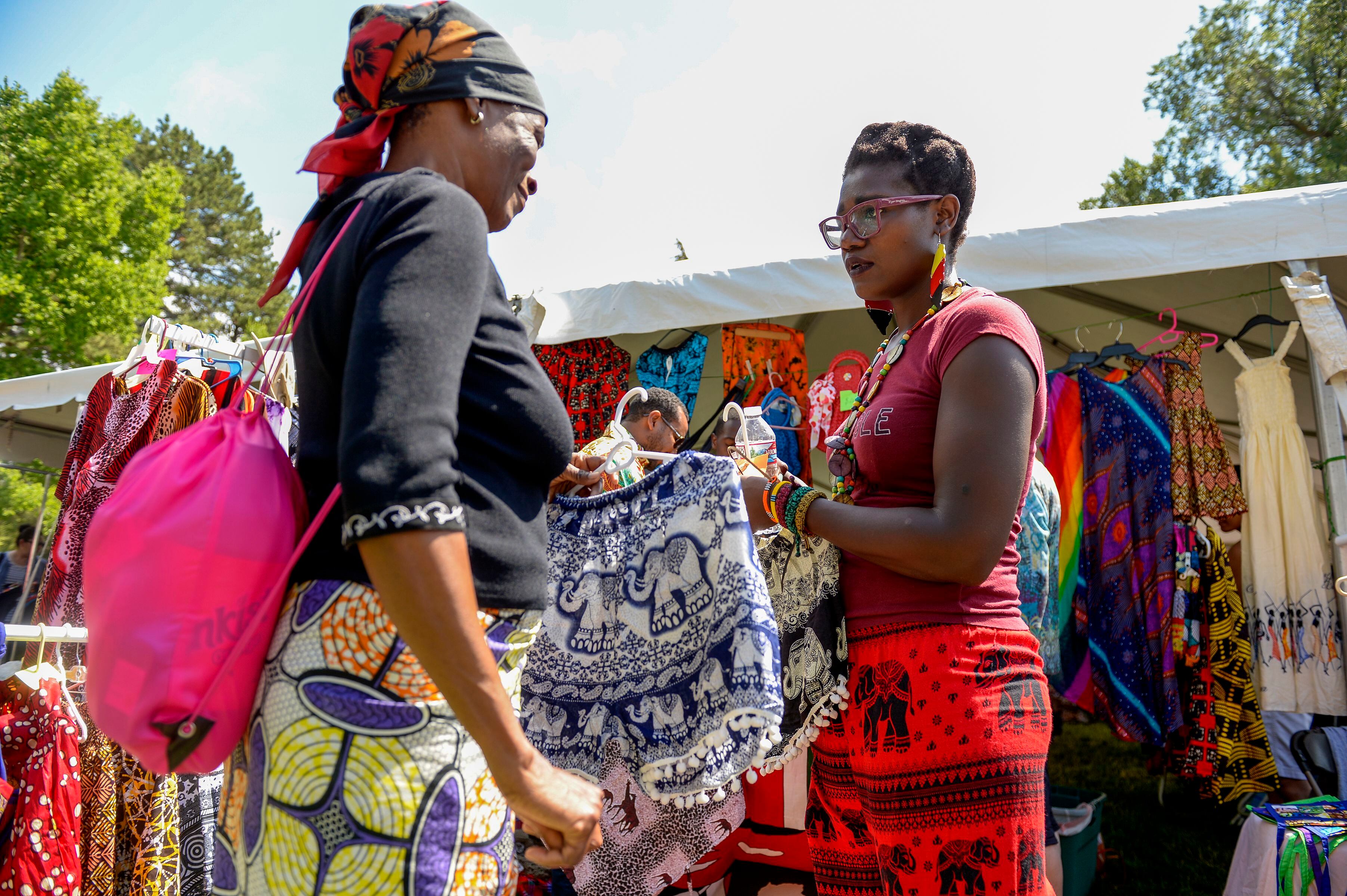 (Leah Hogsten | The Salt Lake Tribune) Emma AngÕila, right, sells Kenyan clothing, artwork and jewelry made by her mother who owns a store in Nairobi during the 4th Annual African Festival sponsored by the United Africans of Utah, Saturday, July 27, 2019 at Liberty Park. The African Festival promotes African tradition, culture and heritage through the arts, food fashion, music and dance.