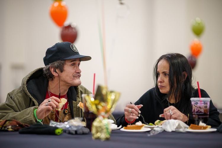 (Trent Nelson  |  The Salt Lake Tribune) "OG" Wayne and Barbara Regules have their Thanksgiving meal as the Miller family provides more than 3,000 meals for people experiencing homelessness at the Salt Palace Convention Center in Salt Lake City on Monday, Nov. 21, 2022.