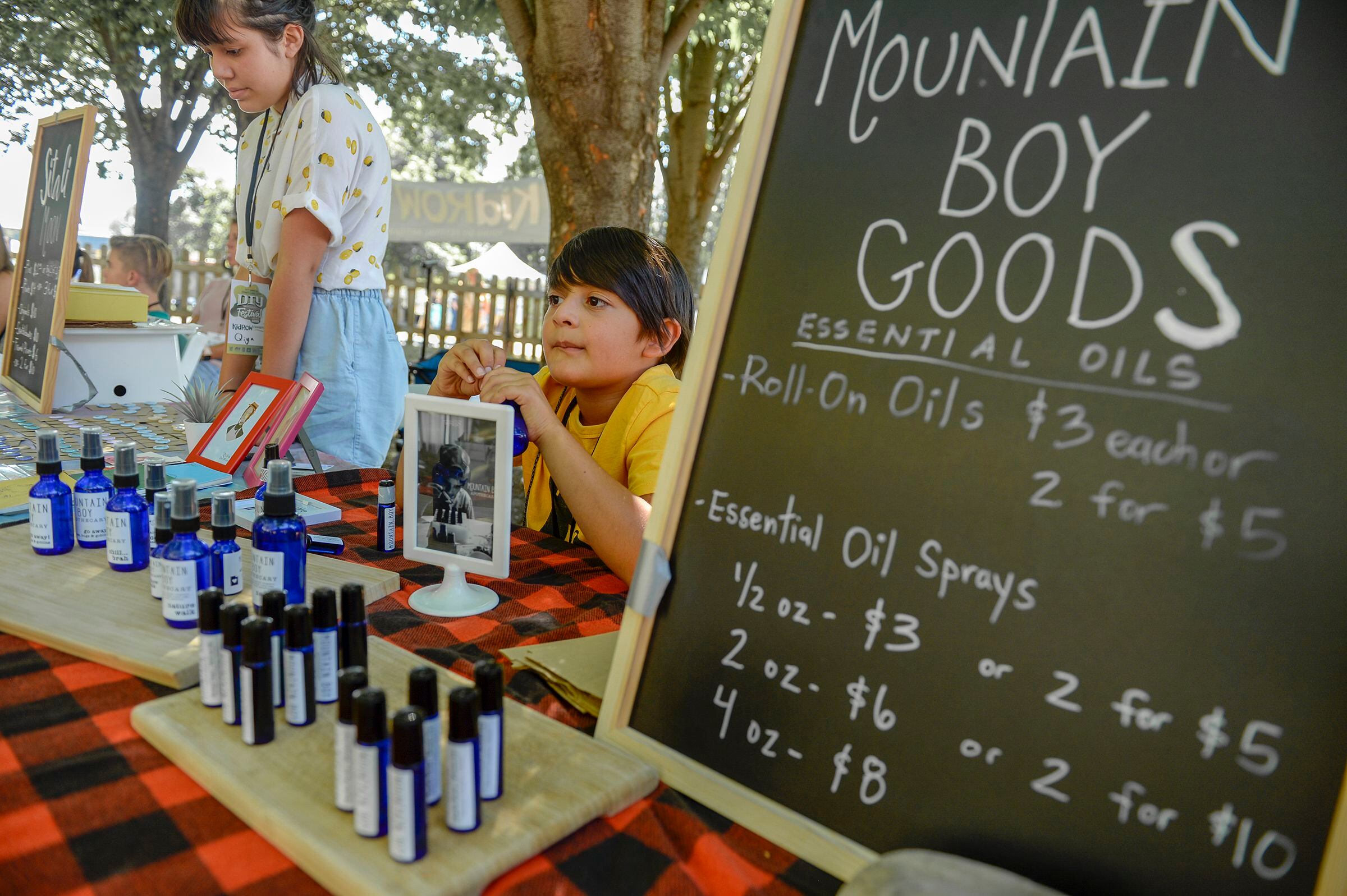 (Leah Hogsten | The Salt Lake Tribune) l-r Qiya Alandia, 11, sells custom art buttons under the name Sitali Moon next to her brother Gyan Alandia, 8, who sells essential oil products under the name Mountain Boy Goods at the Craft Lake City DIY Festival Kid Row, where children 14 and under make and sell their products. Craft Lake CityÕs DIY Festival is UtahÕs largest local, three day arts festival with over 300 artisans, DIY engineers, vintage vendors and craft food creators.