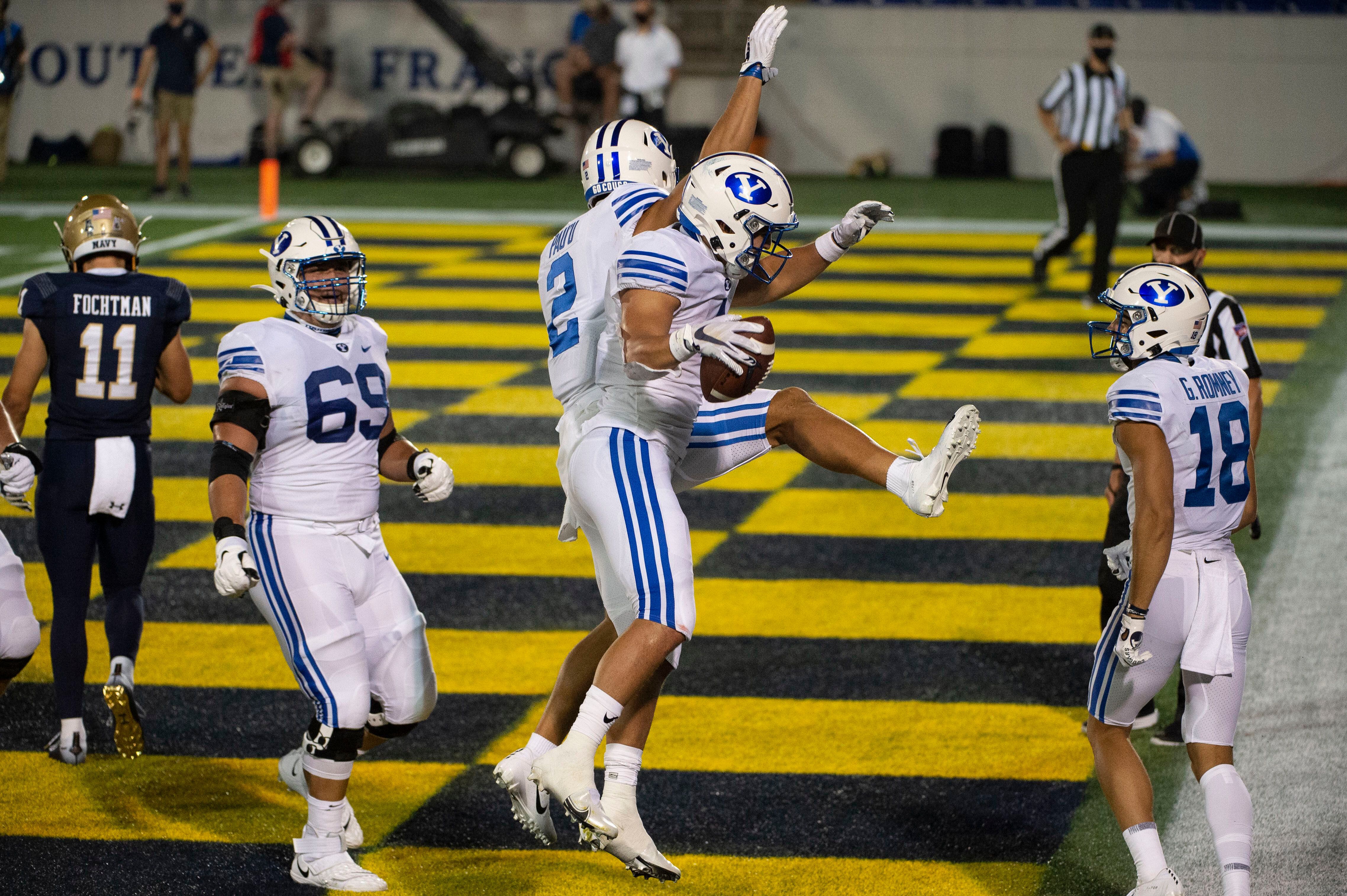 BYU running back Lopini Katoa, center front, celebrates with wide receiver Neil Pau'u (2) after scoring a touchdown during the first half of an NCAA college football game against Navy, Monday, Sept. 7, 2020, in Annapolis, Md. (AP Photo/Tommy Gilligan)