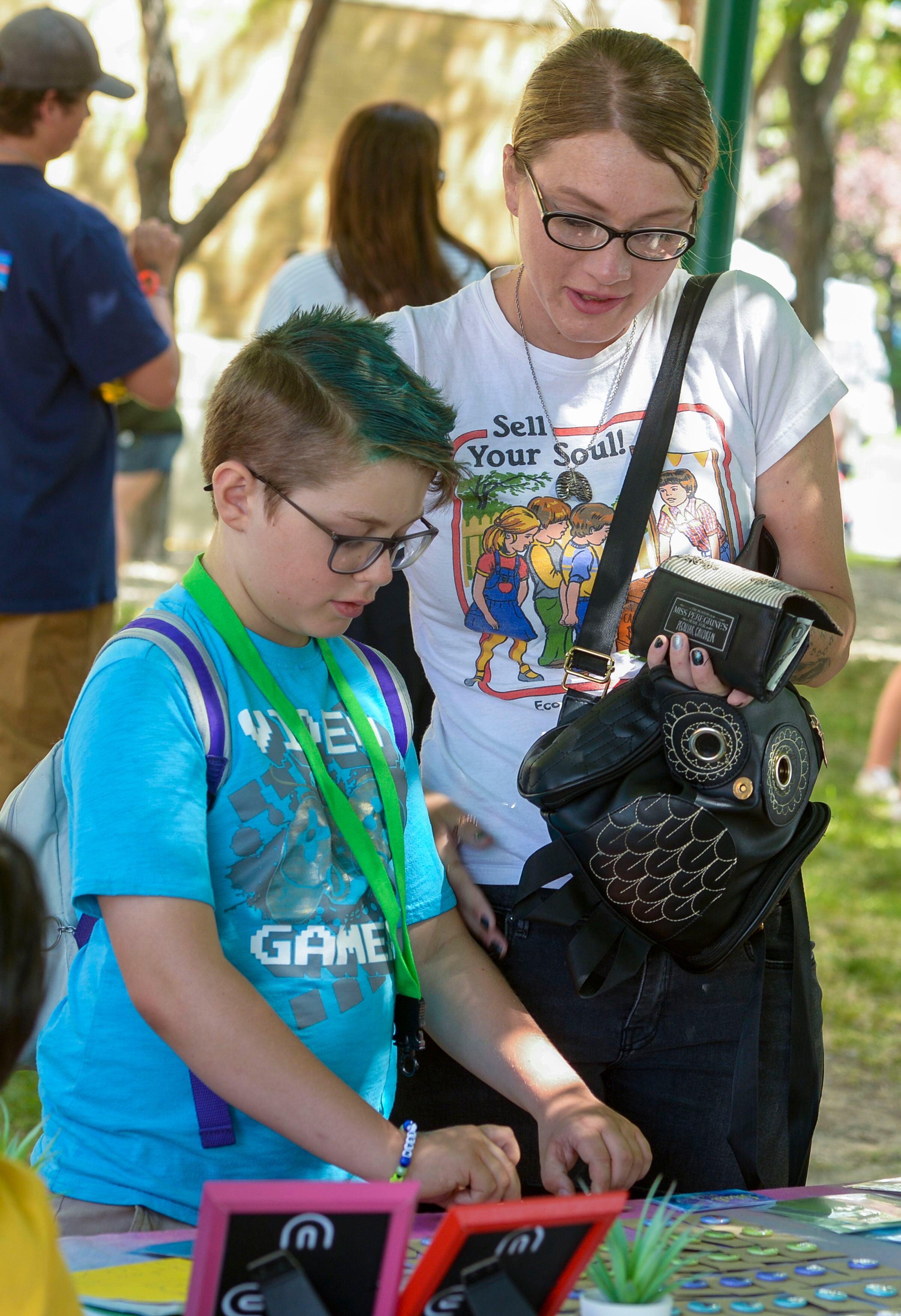 (Leah Hogsten | The Salt Lake Tribune) Keegan Perkins, 11, and his mother Alyssa Tate purchase custom button pins made by Qiya Alandia, 11, at her Sitali Moon booth at Craft Lake City DIY Festival at Kid Row, where children 14 and under make and sell their products. Craft Lake CityÕs DIY Festival is UtahÕs largest local, three day arts festival with over 300 artisans, DIY engineers, vintage vendors and craft food creators.