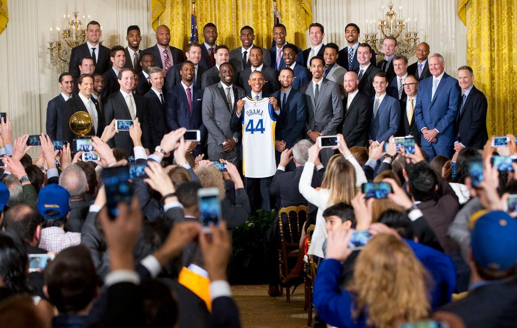 U.S. President Barack Obama accepts a team jersey from head coach