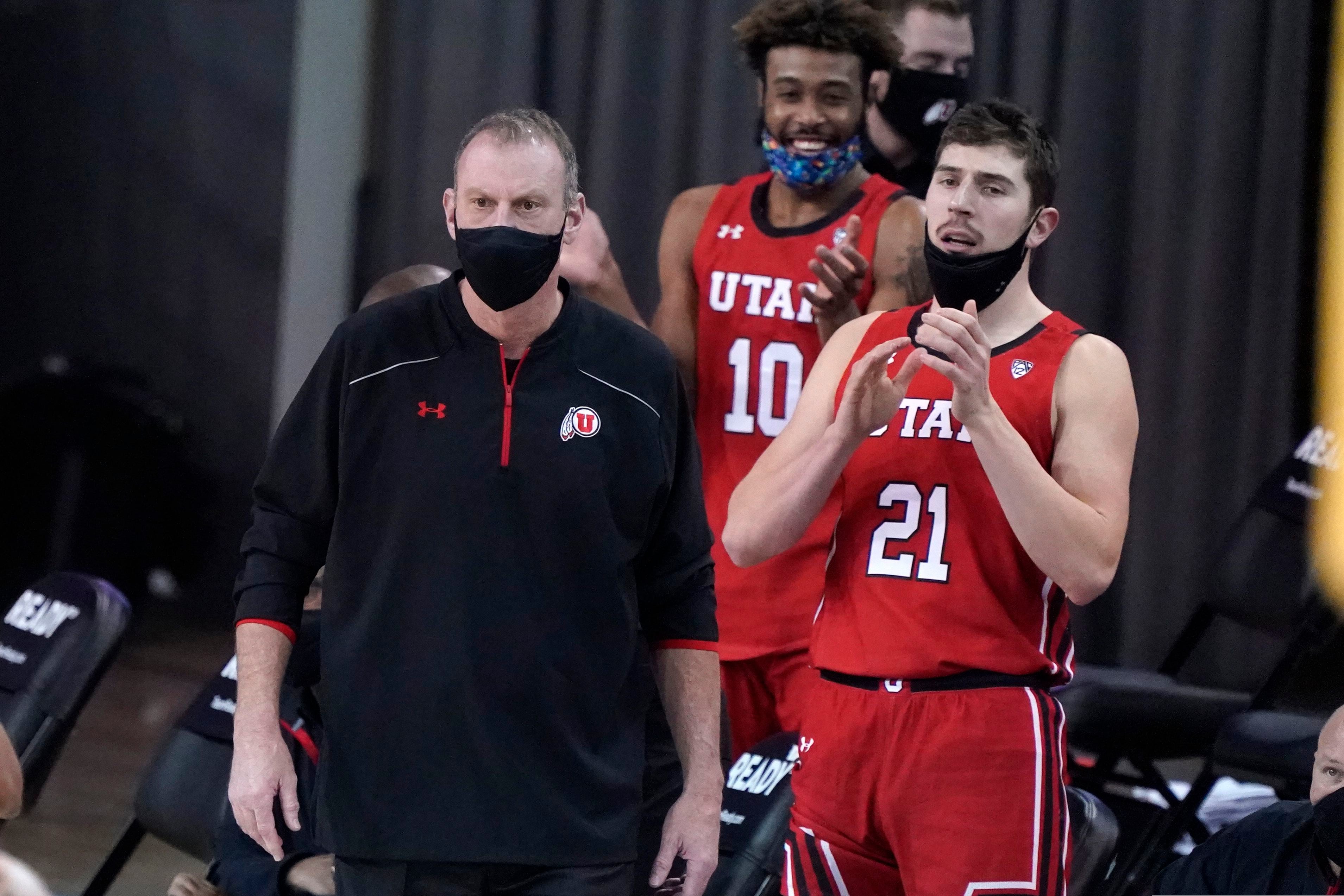Utah coach Larry Krystkowiak, left, watches his team play against UCLA during the first half of an NCAA college basketball game Thursday, Dec. 31, 2020, in Los Angeles. (AP Photo/Marcio Jose Sanchez)