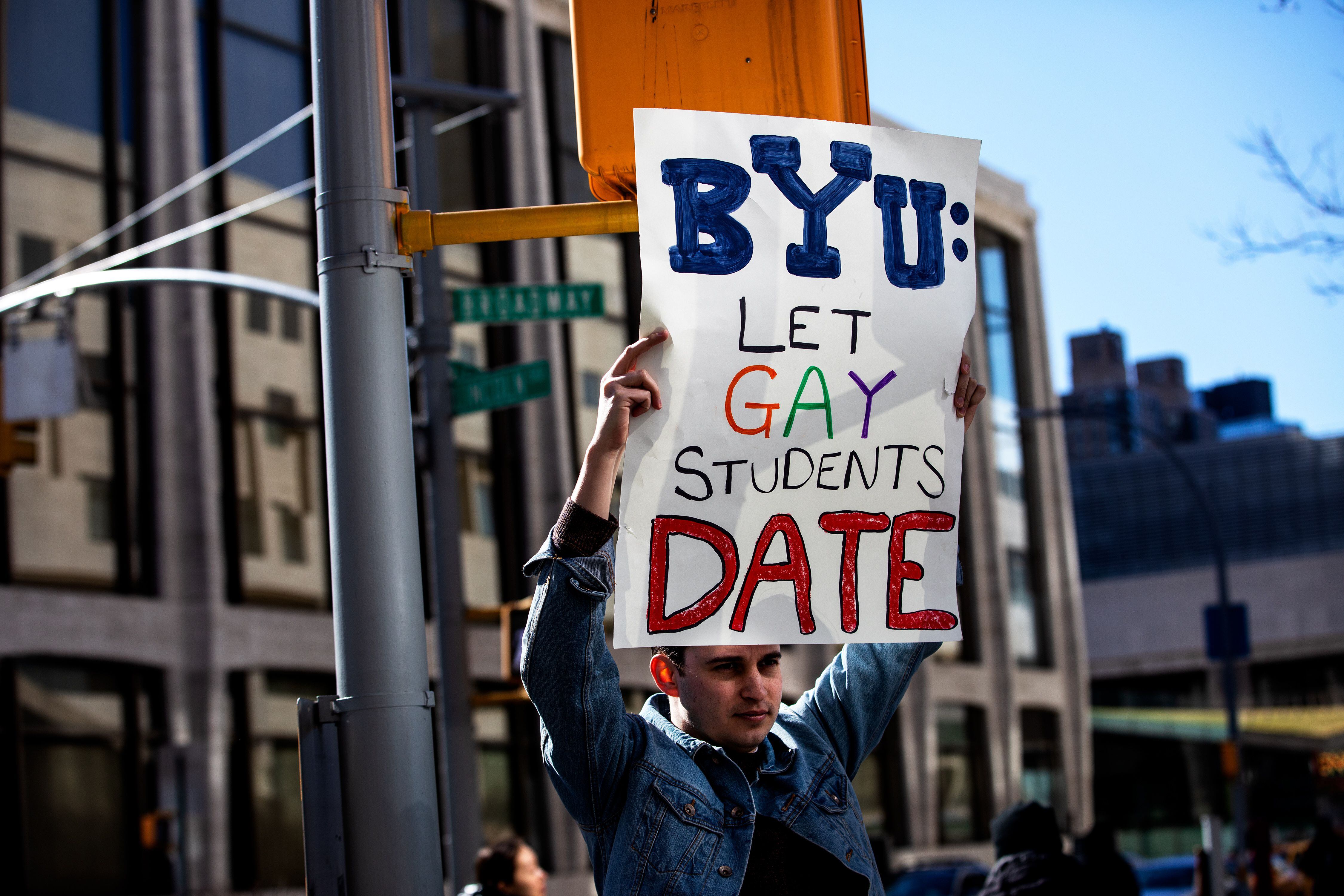 (Demetrius Freeman | for The Salt Lake Tribune) Caleb Jenson, 27, hold up signs during a gathering at Lincoln square across from the Mormon temple in Manhattan, New York, on March 7, 2020, to stand in solidarity with LGBTQ+ students who attending Brigham Young University. Brigham Young University reinstated homophobic policies in their student handbook that prohibit Òhomosexual behavior.Ó