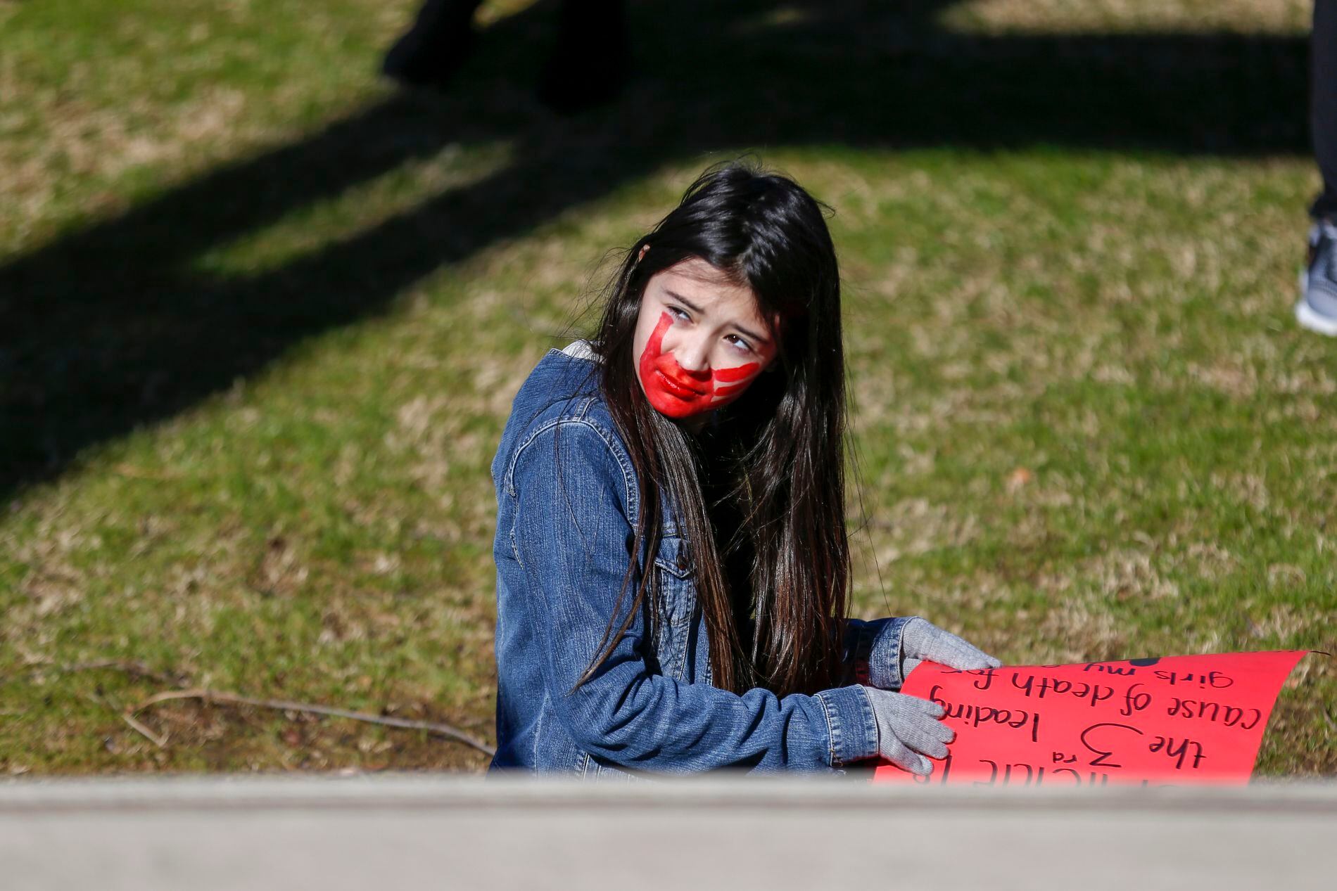 (Ian MauleTulsa World | Tulsa World via AP) Clacey Aldridge, 9, of Tulsa, sits on stairs while listening to a speaker at Guthrie Green during the Women's March in Tulsa on Saturday, Jan. 18, 2020. 