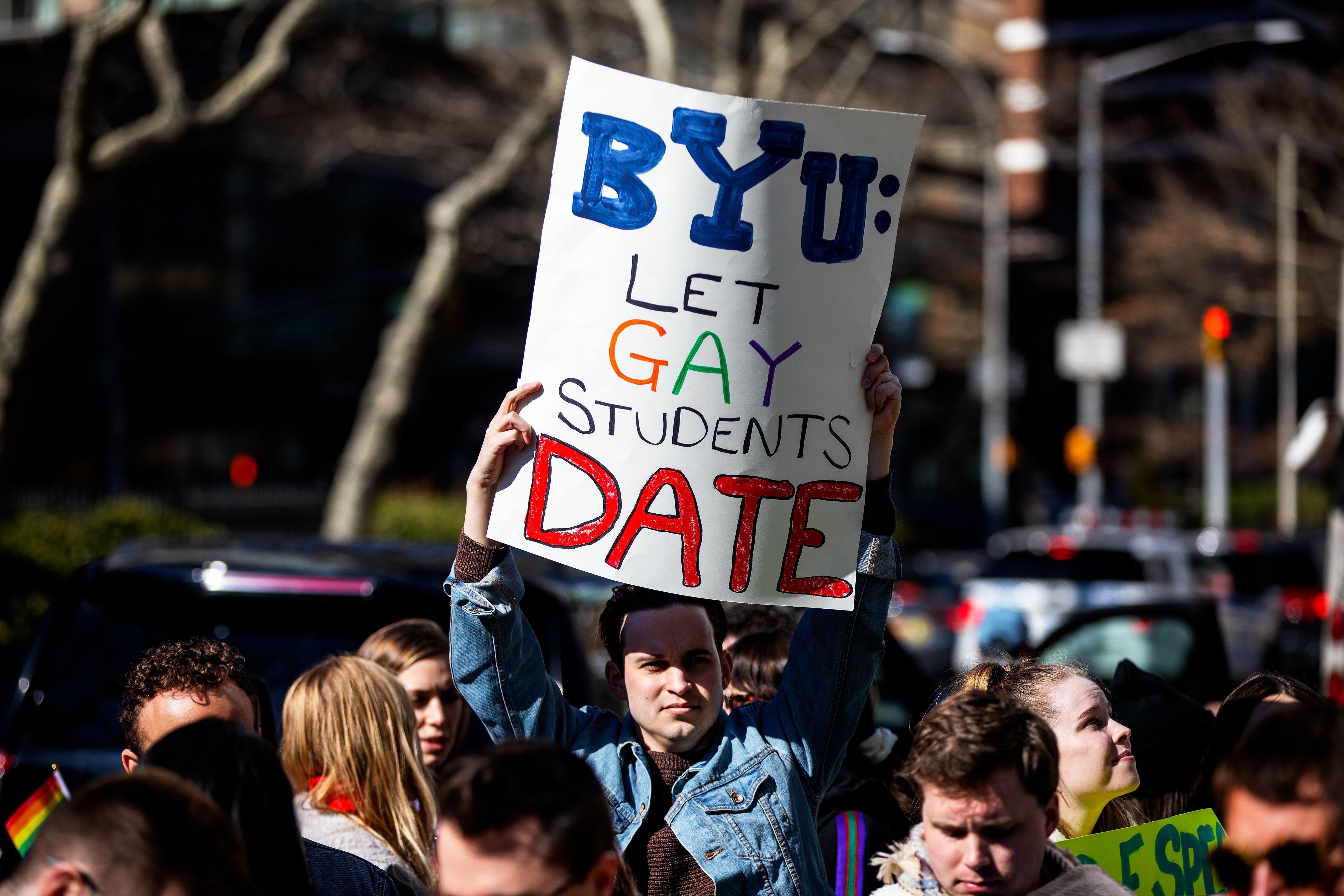 (Demetrius Freeman | for The Salt Lake Tribune) Caleb Jenson, 27, hold up signs during a gathering at Lincoln square across from the Mormon temple in Manhattan, New York, on March 7, 2020, to stand in solidarity with LGBTQ+ students who attending Brigham Young University. Brigham Young University reinstated homophobic policies in their student handbook that prohibit Òhomosexual behavior.Ó