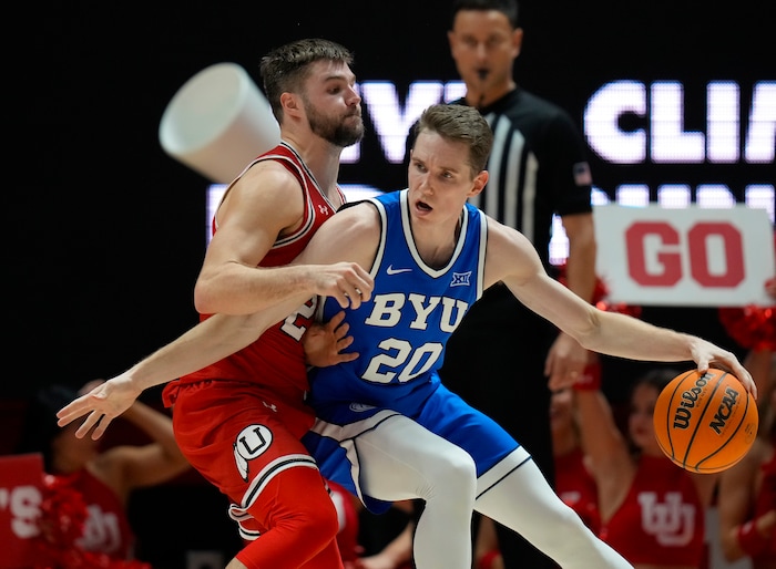 (Bethany Baker  |  The Salt Lake Tribune) Brigham Young Cougars guard Spencer Johnson (20) is defended by Utah Utes guard Rollie Worster (25) at the Jon M. Huntsman Center in Salt Lake City on Saturday, Dec. 9, 2023.