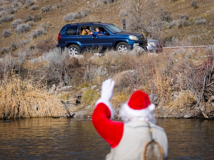 (Bethany Baker  |  The Salt Lake Tribune) Motorists stop and wave at Rudy Schenk, a fly fisherman dressed as Santa Claus, at Vivian Park in Provo Canyon on Saturday, Dec. 23, 2023.