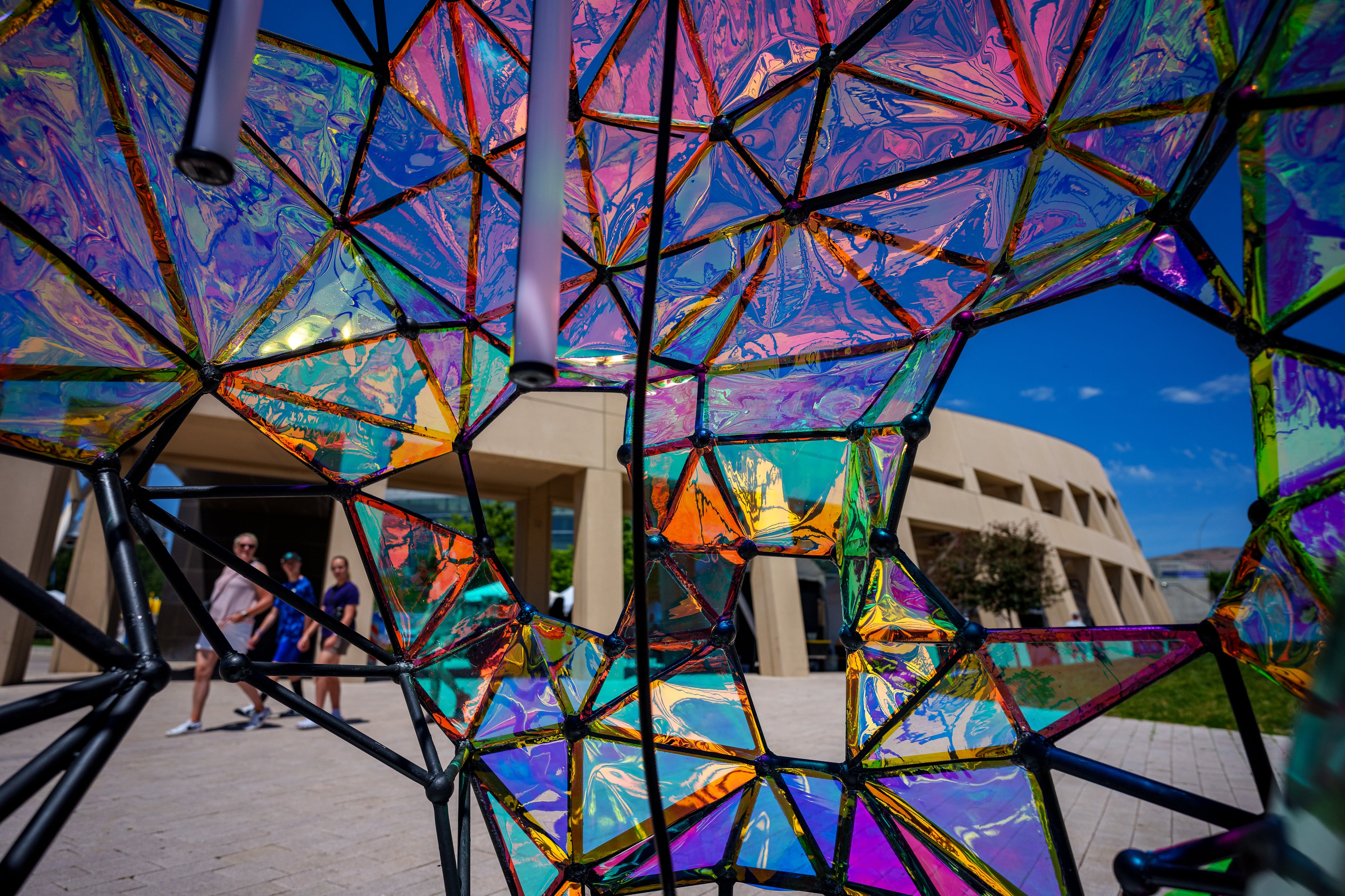 (Trent Nelson | The Salt Lake Tribune) People seen through the Dichroic Skull at the Utah Arts Festival in Salt Lake City on Friday, June 28, 2024.