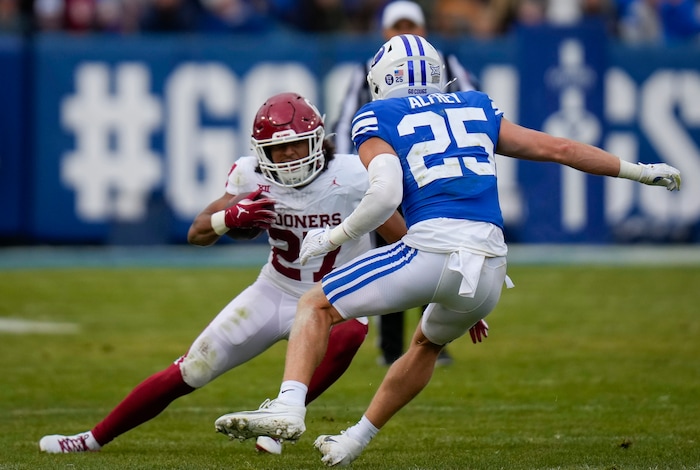 (Bethany Baker  |  The Salt Lake Tribune) Oklahoma Sooners running back Gavin Sawchuk (27) runs the ball as Brigham Young Cougars safety Talan Alfrey (25) defends at LaVell Edwards Stadium in Provo on Saturday, Nov. 18, 2023.