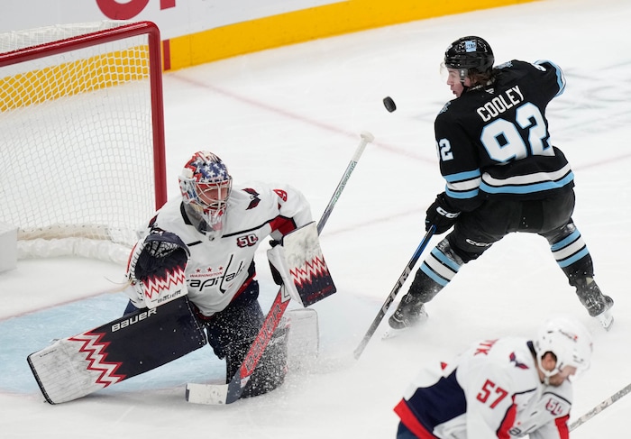 (Francisco Kjolseth  | The Salt Lake Tribune) Washington Capitals goaltender Charlie Lindgren (79) blocks a shot from Utah Hockey Club center Logan Cooley (92) during a NHL hockey game at the Delta Center in Salt Lake City on Monday, Nov. 18, 2024.