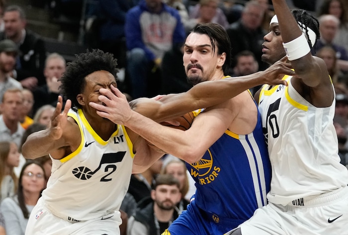 (Francisco Kjolseth  |  The Salt Lake Tribune) Utah Jazz guard Collin Sexton (2) gets a hand to the face by Golden State Warriors forward Dario Saric (20) as Utah Jazz forward Taylor Hendricks (0) also defends during an NBA basketball game Thursday, Feb. 15, 2024, in Salt Lake City.