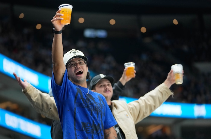 (Francisco Kjolseth  | The Salt Lake Tribune) Hockey fans raise a beer hoping to chug on camera during an NHL hockey game at the Delta Center in Salt Lake City on Wednesday, Oct. 30, 2024.