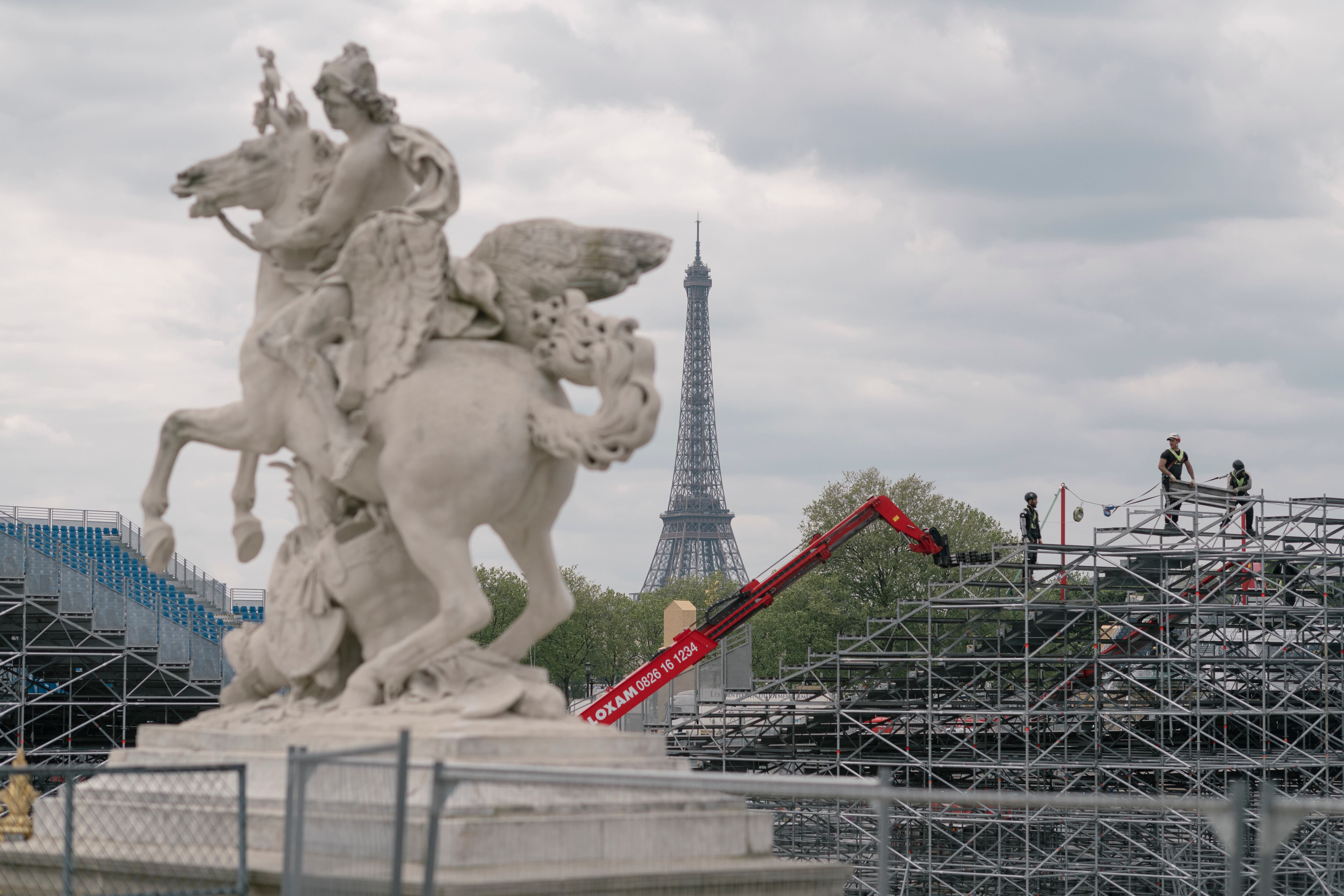 (Dmitry Kostyukov | The New York Times) Workers install temporary bleachers at the Place de la Concorde in Paris, ahead of the Summer Olympics on April 4, 2024.