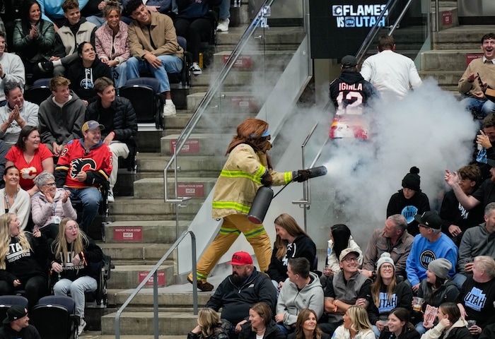 (Francisco Kjolseth  | The Salt Lake Tribune) Bear smokes out a Calgary Flames fan during an NHL hockey game against the Utah Hockey Club at the Delta Center in Salt Lake City on Wednesday, Oct. 30, 2024.