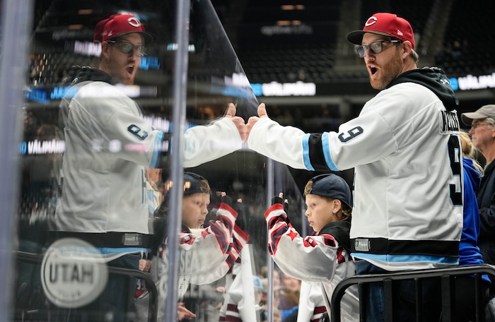 (Francisco Kjolseth  | The Salt Lake Tribune) Evan Kynaston and his son Kayden, 7, cheer on the Utah Hockey Club as they warm up for their game against the Washington Capitols during an NHL hockey game at the Delta Center in Salt Lake City on Monday, Nov. 18, 2024.