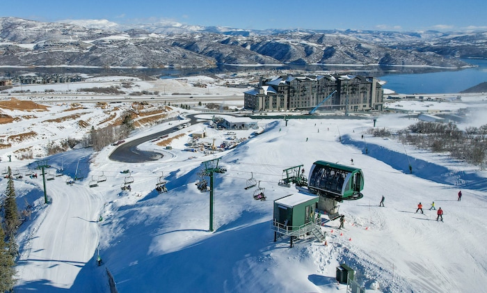 (Francisco Kjolseth  | The Salt Lake Tribune) Skiers disembark from Deer Valley Resort's new Aurora lift above the new Grand Hyatt on Tuesday, Dec. 31, 2024. It was the first day the ski area opened the four-person lift along with the six-person Keetley Express bubble lift, the first two lifts to operate out of Deer Valley's new East Village base.