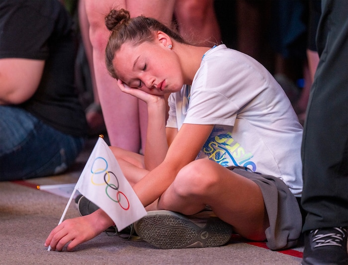 (Rick Egan | The Salt Lake Tribune) Peyton Eagan, 11, rests during the long speeches broadcast at Salt Lake City Hall before the IOC vote for the 2034 Winter Olympics, on Wednesday, July 24, 2024.