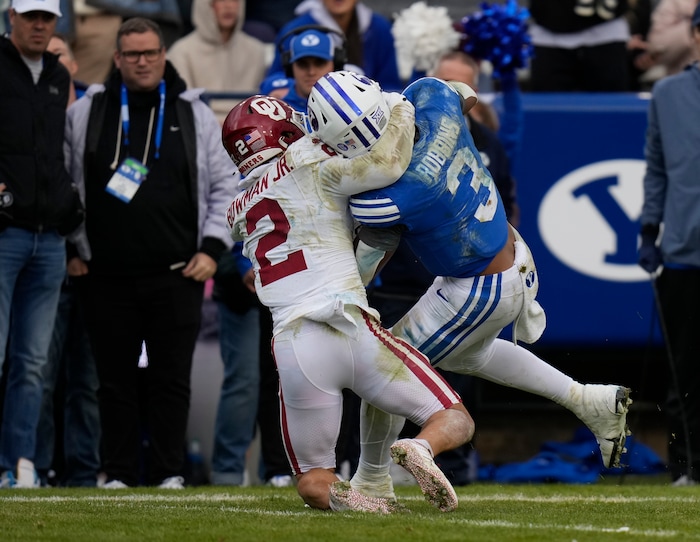 (Bethany Baker  |  The Salt Lake Tribune) Oklahoma Sooners defensive back Billy Bowman Jr. (2) tackles Brigham Young Cougars running back Aidan Robbins (3) at LaVell Edwards Stadium in Provo on Saturday, Nov. 18, 2023.