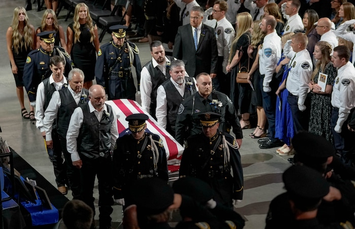 (Francisco Kjolseth  |  The Salt Lake Tribune) Pallbearers carry the casket containing Santaquin police Sgt. Bill Hooser following services at the UCCU Center at Utah Valley University on Monday, May 13, 2024.