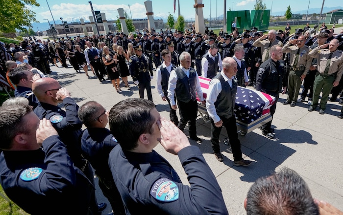 (Francisco Kjolseth  |  The Salt Lake Tribune) Pallbearers carry the casket containing Santaquin police Sgt. Bill Hooser following services at the UCCU Center at Utah Valley University on Monday, May 13, 2024.