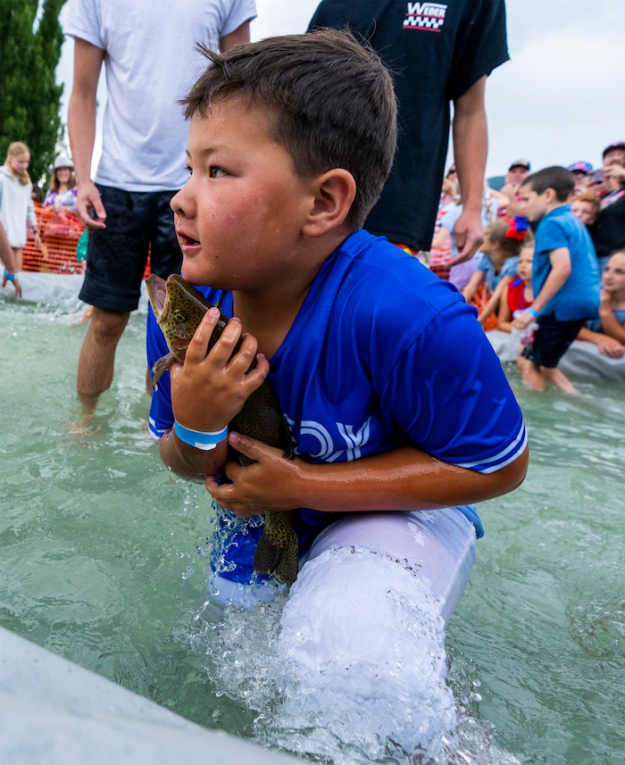 (Rick Egan | The Salt Lake Tribune) Kai Roundy holds the big trout he caught with his bare hands during the Fish Catch, at the Liberty Days celebration in Liberty, Utah, on Tuesday, July 4, 2023.   