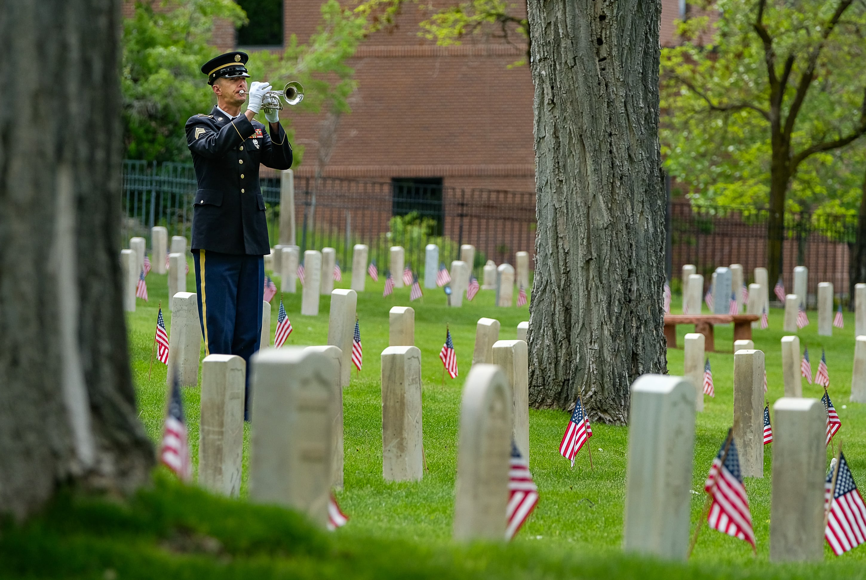 (Francisco Kjolseth | The Salt Lake Tribune) Sgt. Aaron Reynolds plays taps on his bugle as the Association of the United States Army - AUSA - Utah Chapter, hosts a Memorial Day Ceremony at Fort Douglas Cemetery on Monday, May 27, 2019.