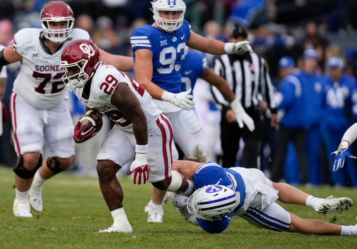 (Bethany Baker  |  The Salt Lake Tribune) Brigham Young Cougars safety Talan Alfrey (25) tackles Oklahoma Sooners running back Tawee Walker (29) at LaVell Edwards Stadium in Provo on Saturday, Nov. 18, 2023.