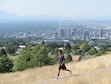 (Al Hartmann  |  The Salt Lake Tribune) A hiker jogs down the path from Ensign Peak above Salt Lake City in July 2017. What can be an amazing view of the valley is diminished by an ozone haze.