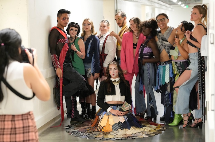 (Francisco Kjolseth | The Salt Lake Tribune) Fashion designer Sage Nelsen, in pink, is joined by her crew for a group photo behind the scenes at the Eccles Theater on Friday, July 21, 2023, before going onstage for Main Street: A Fashion and Music Experience.