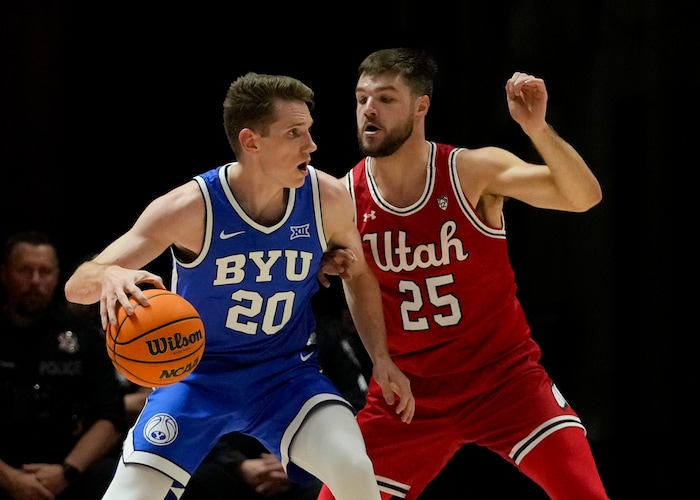 (Bethany Baker  |  The Salt Lake Tribune) Brigham Young Cougars guard Spencer Johnson (20) dribbles around Utah Utes guard Rollie Worster (25) at the Jon M. Huntsman Center in Salt Lake City on Saturday, Dec. 9, 2023.