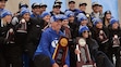 (Joseph C. Garza | Tribune-Star via AP) Brigham Young University men's cross country coach Ed Eyestone and women's coach Diljeet Taylor pose with their National Champion and National Runner-Up trophies, respectively, on the awards podium with their runners on Saturday, Nov. 23, 2019 after the NCAA Div. I Cross Country Championships. The Cougars swept the championships this year, as both the men's and women's teams claimed NCAA titles.