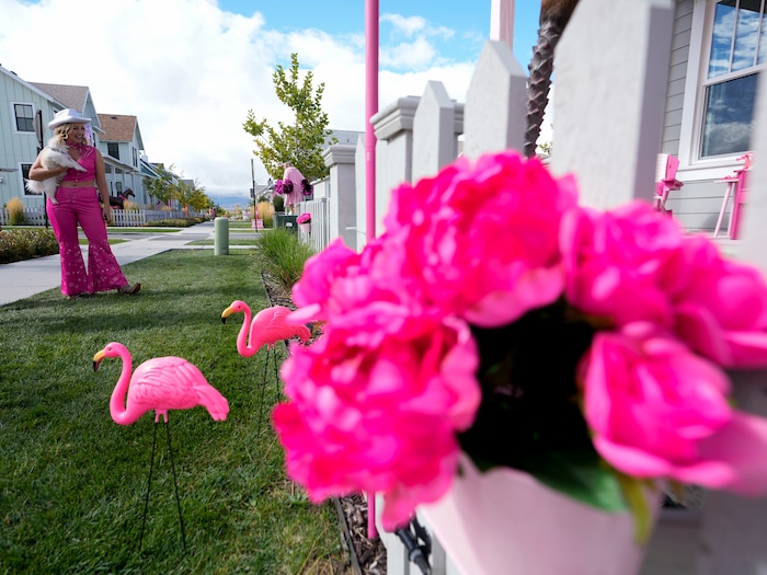 (Bethany Baker  |  The Salt Lake Tribune) Jamie Tucker, dressed as “Classic Barbie” from the movie “Barbie,” stands in front of her decorated home in a section of Daybreak that has collectively created a Barbieland-themed community for Halloween on Wednesday, Oct. 11, 2023.