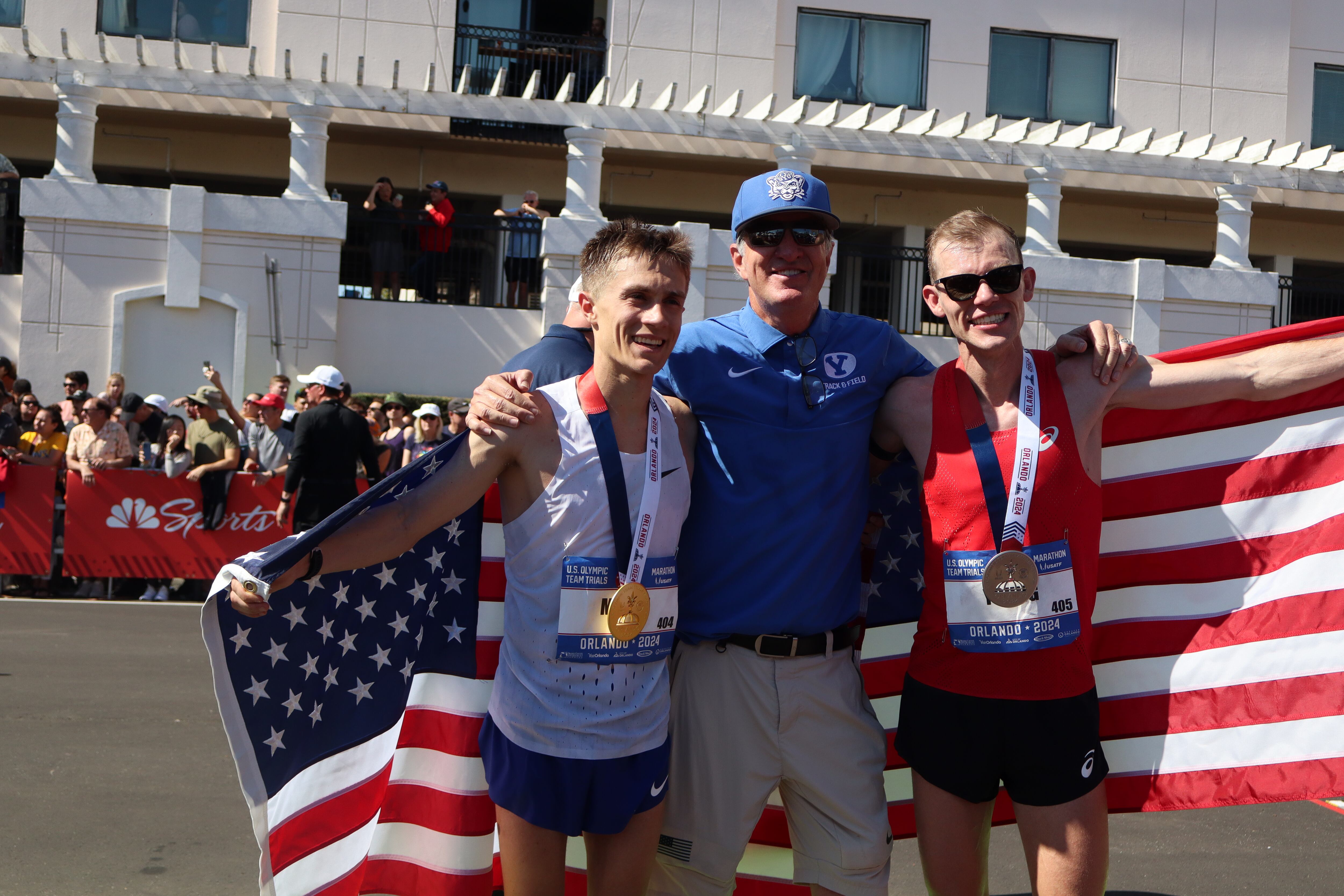 (Landon Southwick | REP) Conner Mantz, left, and Clayton Young of Utah celebrate with their BYU and pro coach Ed Eyestone at the U.S. Olympic Marathon Trials in Orlando, Fla., on Saturday, Feb. 3, 2024. Mantz won and Young took second to claim the nation's two guaranteed berths in the Paris 2024 marathon.
