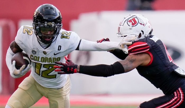 (Bethany Baker  |  The Salt Lake Tribune) Colorado Buffaloes cornerback Travis Hunter (12) blocks a tackle from Utah Utes cornerback JaTravis Broughton (4) at Rice-Eccles Stadium in Salt Lake City on Saturday, Nov. 25, 2023.