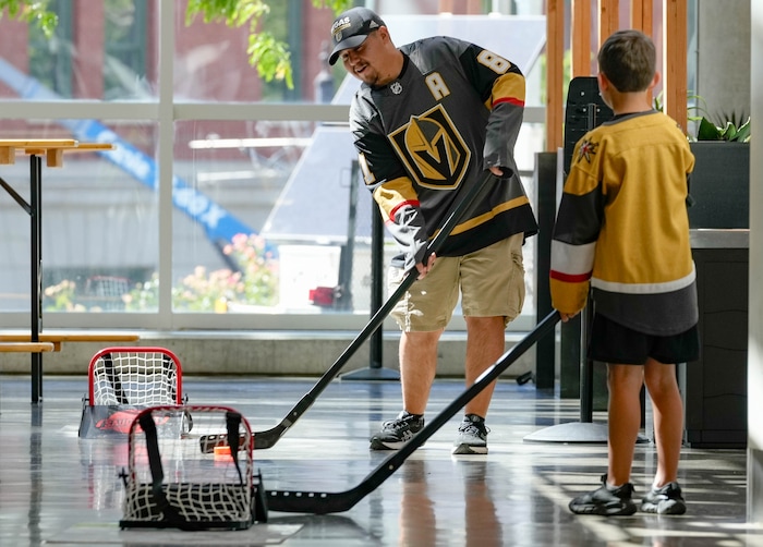 (Francisco Kjolseth  |  The Salt Lake Tribune) Arturo Zamora plays a little hockey with his step-son Emerson Mortensen, 9, as the Utah Hockey Club hosts their first NHL draft party at the Delta Center on Friday, June 28, 2024.