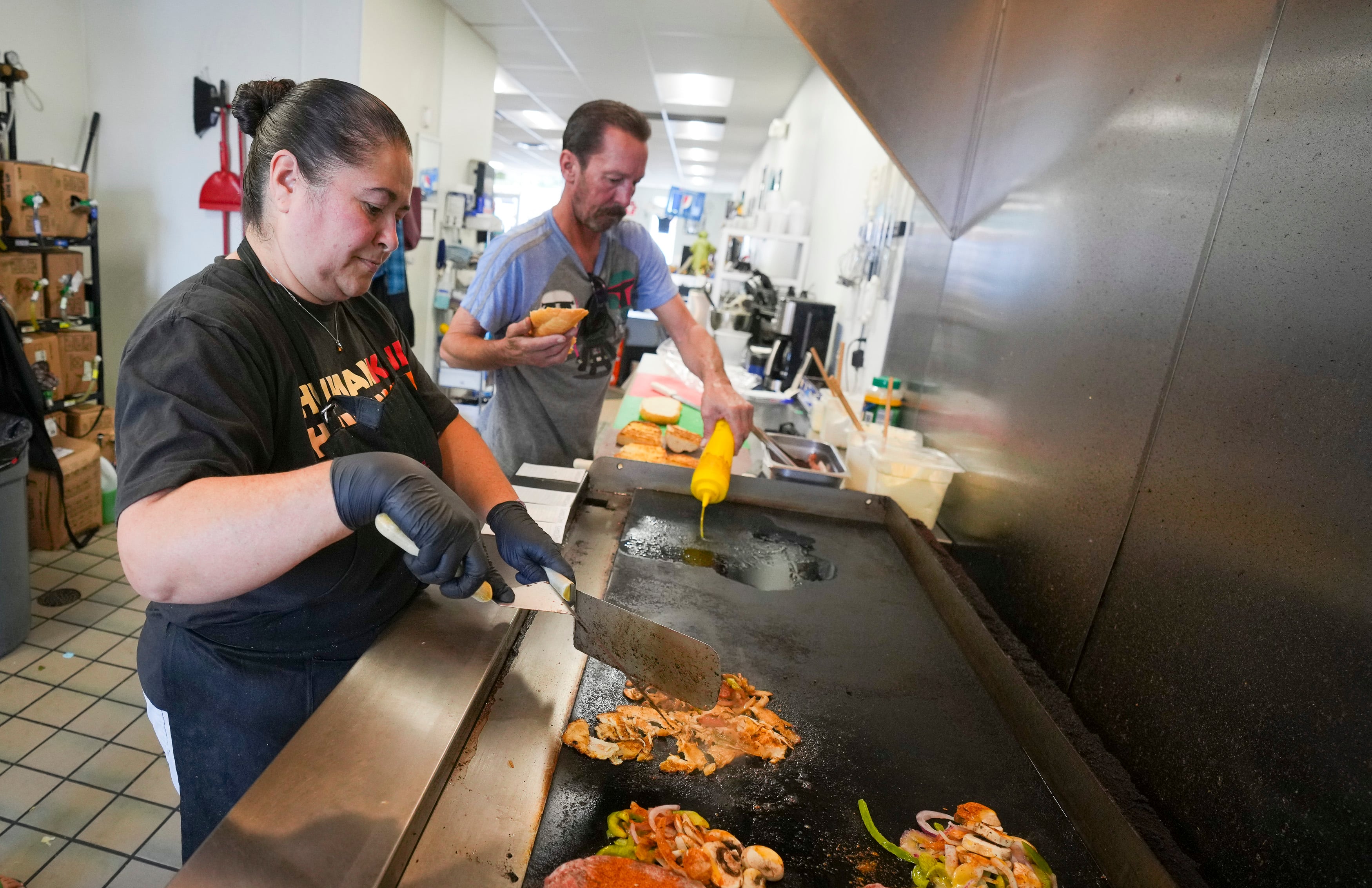 (Bethany Baker | The Salt Lake Tribune) Stephanie Clarke, left, and her husband Rick Clarke prepare food at That Sandwich Shop in Salt Lake City on Aug. 5, 2024.