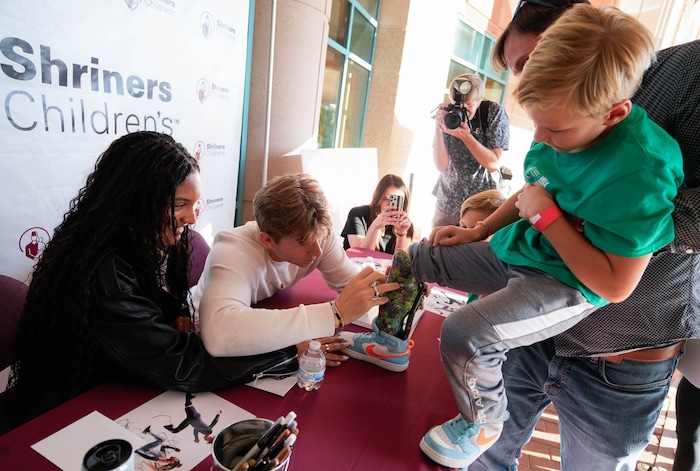 (Francisco Kjolseth  | The Salt Lake Tribune) Zach Adler, 8, has his prosthetic signed by Hunter Woodhall and Tara Davis- Woodhall, both gold medalists in the Paris 2024 Games, during a visit to Shriners Children’s Hospital on Wednesday, Sept. 18, 2024. Woodhall had his legs amputated when he was 11 months old and spent much of his youth at the hospital.