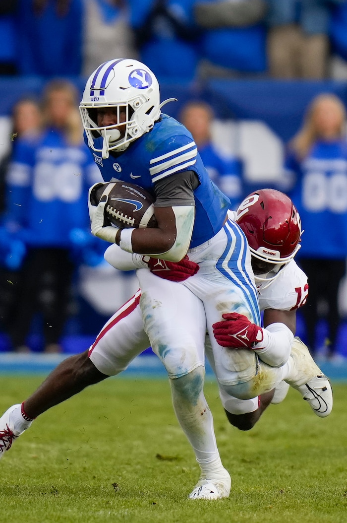 (Bethany Baker  |  The Salt Lake Tribune) Brigham Young Cougars running back Aidan Robbins (3) runs the ball as Oklahoma Sooners defensive back Key Lawrence (12) tackles during the game at LaVell Edwards Stadium in Provo on Saturday, Nov. 18, 2023.