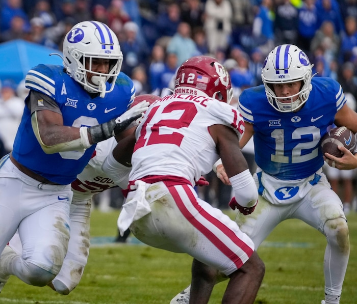 (Bethany Baker  |  The Salt Lake Tribune) Brigham Young Cougars running back Aidan Robbins (3) blocks for Brigham Young Cougars quarterback Jake Retzlaff (12) as Oklahoma Sooners defensive back Key Lawrence (12) defends at LaVell Edwards Stadium in Provo on Saturday, Nov. 18, 2023.