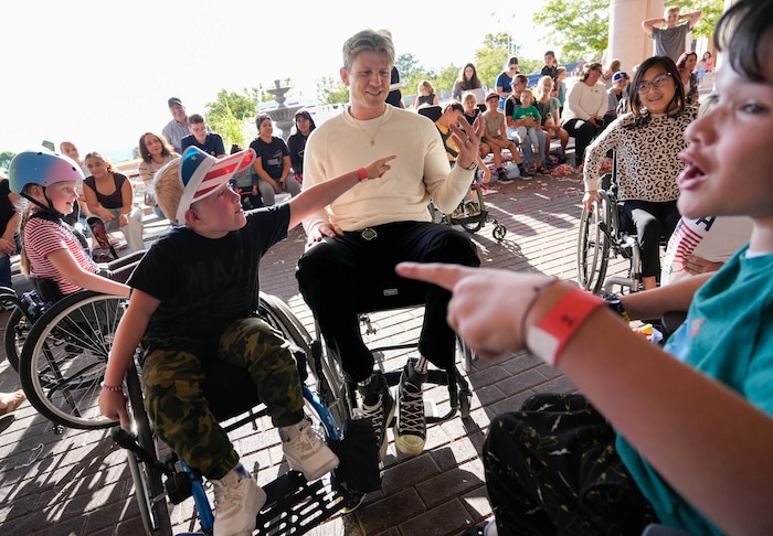 (Francisco Kjolseth  | The Salt Lake Tribune) Young patients at Shriners Children’s Hospital in Salt Lake City dish out a healthy dose of smack talk after racing Paralympic athlete Hunter Woodhall during a visit on Wednesday, Sept. 18, 2024. Woodhall had his legs amputated when he was 11 months old and spent much of his youth at the hospital.