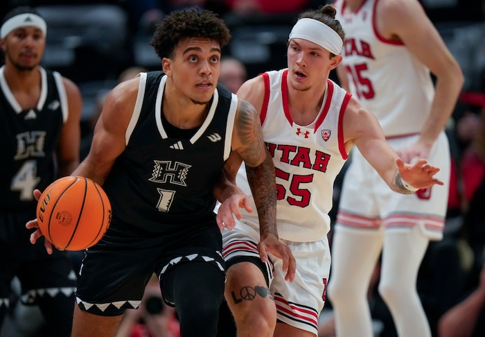 (Bethany Baker  |  The Salt Lake Tribune) Hawaii Warriors forward Justin McKoy (1) moves the ball as Utah Utes guard Gabe Madsen (55) defends at the Delta Center in Salt Lake City on Thursday, Nov. 30, 2023.
