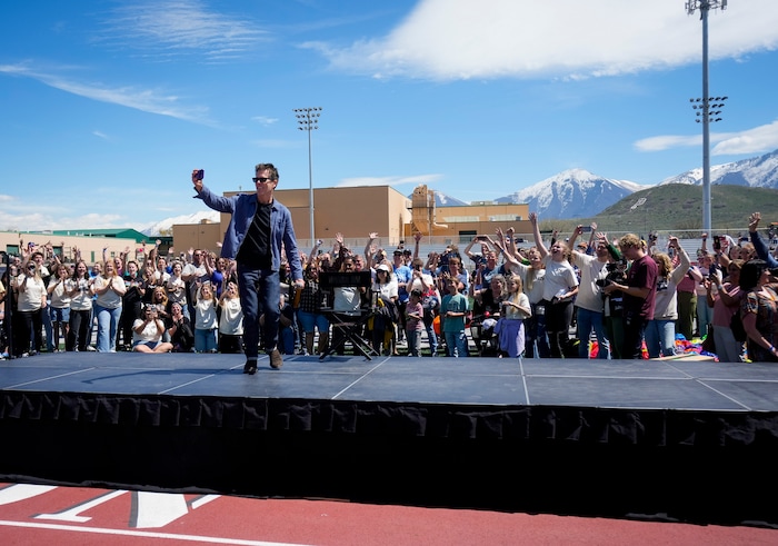 (Bethany Baker  |  The Salt Lake Tribune) Kevin Bacon records a video with the crowd, playing into the "six degrees from Kevin Bacon" game, following a charity event to commemorate the 40th anniversary of the movie "Footloose" on the football field of Payson High School in Payson on Saturday, April 20, 2024.