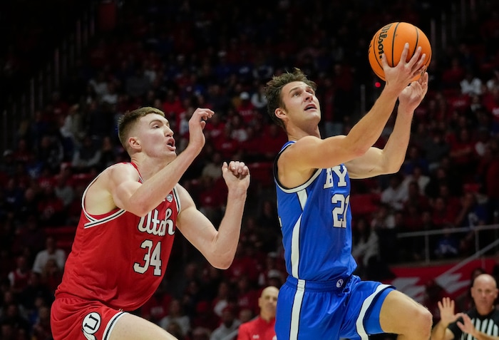 (Bethany Baker  |  The Salt Lake Tribune) Brigham Young Cougars guard Trevin Knell (21) goes for a lay up as Utah Utes center Lawson Lovering (34) defends at the Jon M. Huntsman Center in Salt Lake City on Saturday, Dec. 9, 2023.