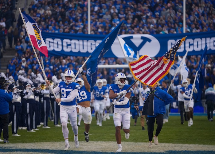 (Bethany Baker  |  The Salt Lake Tribune) Brigham Young Cougars run out before the game against the Oklahoma Sooners at LaVell Edwards Stadium in Provo on Saturday, Nov. 18, 2023.